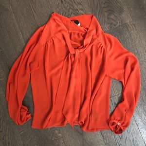 Blouse with bow detail around neck.